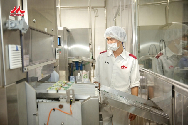 A person in a white coat and mask in a factoryAI-generated content may be incorrect.